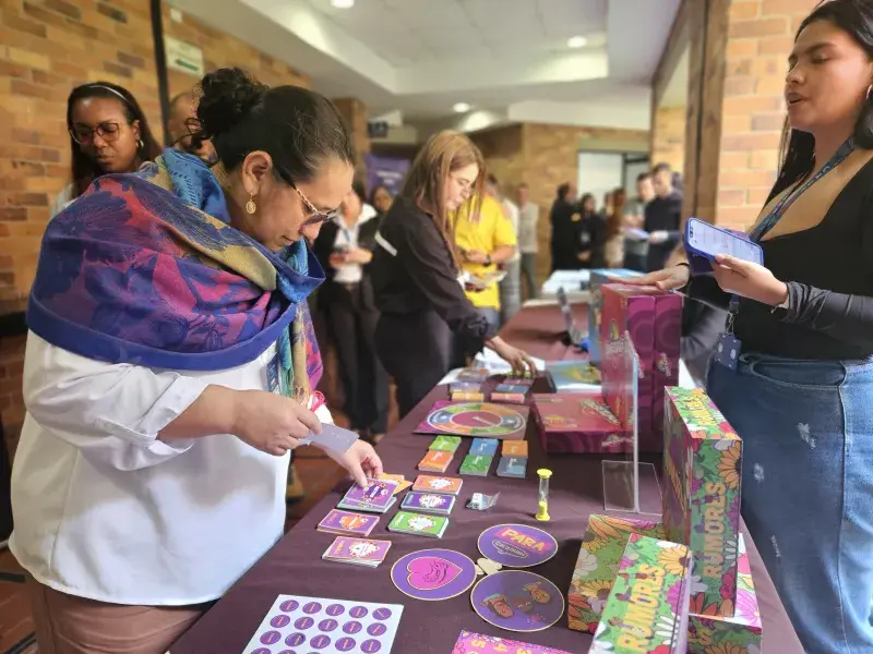 Participantes del  II Foro Andino Por la Salud de Ellas visitando e interactuando en el stand de juegos educativos salud sexual y reproductiva de la Javeriana Cali